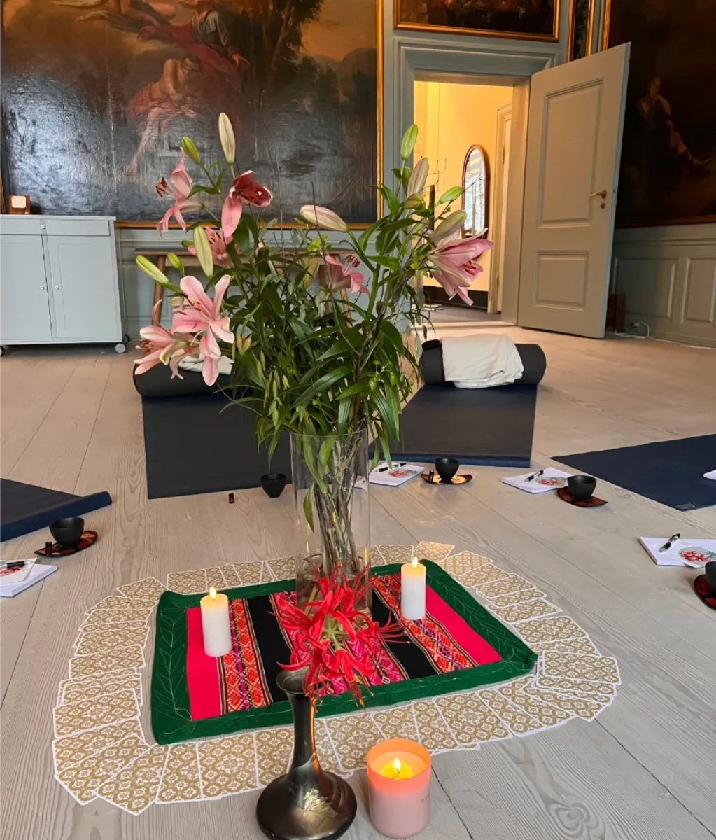 Cacaoceremoni med blomster, lys og yogamåtter